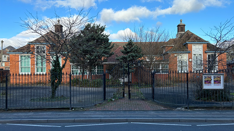 The front of a school outside locked gates.