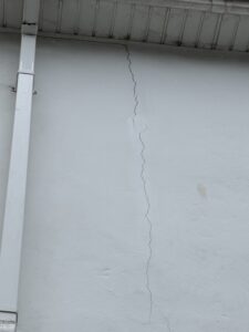 a fine hairline crack running up the outside of a house